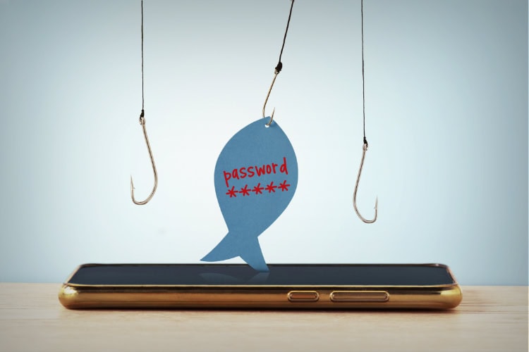 Symbolische Darstellung eines Phishing-Angriffs: Drei Angelhaken hängen über einem Smartphone, einer davon hält ein Papier in Fischform mit dem Wort ‚password‘ und Sternchen, die ein Passwort andeuten.