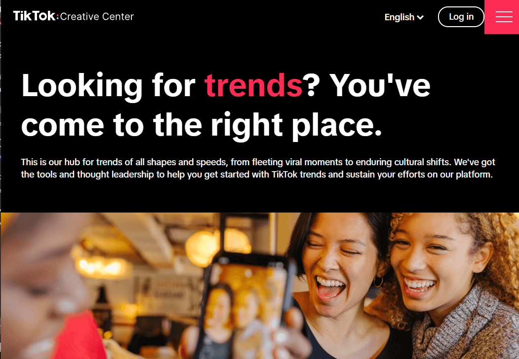Screenshot der TikTok Creative Center Website mit dem Slogan ‚Looking for trends? You’ve come to the right place.‘ sowie einem Bild von drei lachenden Personen, die ein Selfie machen.