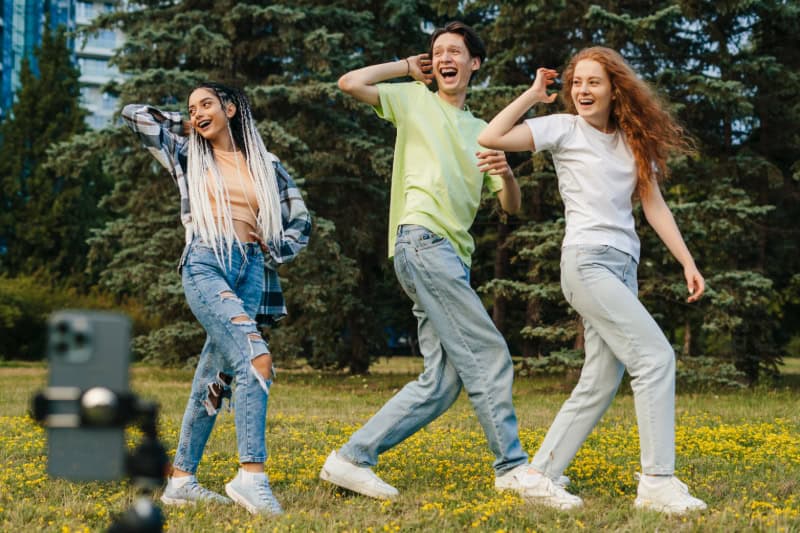 Jugendliche beim Tanz mit Smartphone, Parkszene, Choreografie.